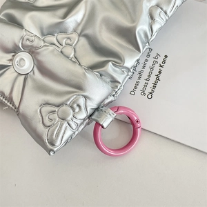 Detail of silver quilted butterfly texture with a pink hook for earphone case