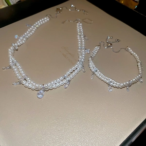 Detail shot of double-layer pearl necklace and bracelet set with teardrop zircon charms
