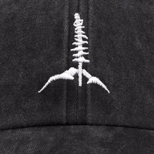 Washed black cotton baseball cap featuring white embroidered mountain and pine tree landscape