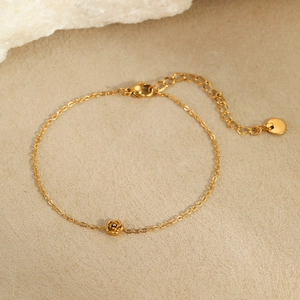 Delicate gold stainless steel bracelet featuring a 3D rose pendant with adjustable chain