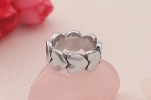 Detailed view of silver heart-shaped ring placed on a decorative pink quartz stone