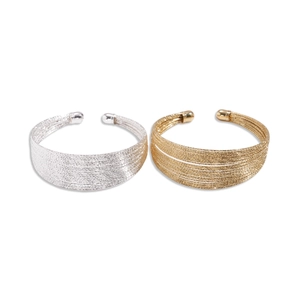 Layered geometric open cuffs in gold and silver finish with textured metallic surface