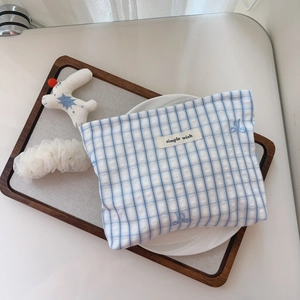 Detailed view of blue plaid cotton makeup bag with simple wish label and bunny embroidery