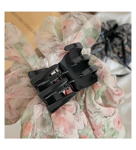 Detail of large floral chiffon ribbon hair claw clip showing bow fabric texture