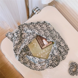 Detailed top view of black and white floral cotton tote bag with matching hair scrunchie