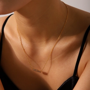 Detail of 18K gold plated necklace with MOM pendant featuring sparkling inlaid crystals