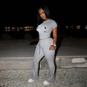 Detailaufnahme des grauen Cropped-T-Shirts mit Aufdruck und passender hoch taillierter Hose