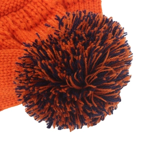 Gros plan du bonnet en maille orange vif avec un pompon duveteux de couleur mélangée