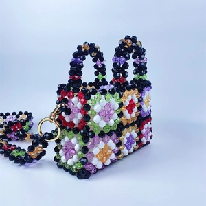 Macro detail of colorful beaded handbag with floral pattern and gold metal ring