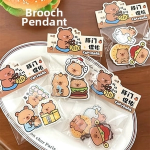 Macro detail of cute capybara acrylic charms and pins in various themed costumes