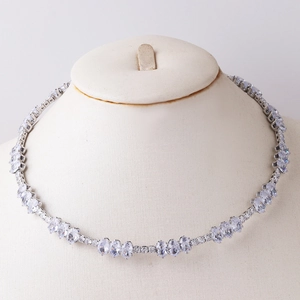 Detailed close-up of a silver collar necklace with heart and drop-shaped cubic zirconia