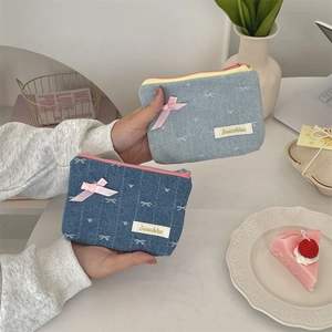 Detail of denim coin purses with pink ribbon bows and delicate bow embroidery patterns