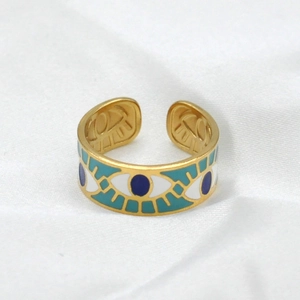 Detail view of adjustable gold evil eye ring with colorful enamel inlay patterns