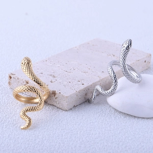 Macro detail of snake rings in gold and silver showing scales on stone surfaces