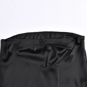 Détail du tissu en satin noir avec taille élastique et boucle métallique de robe