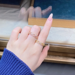 Close-up of 18K gold and rose gold chain rings with pave zircon on female hand