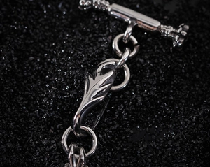 Macro shot of silver stainless steel wolf head bracelet with detailed T-bar toggle clasp