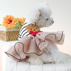 Pink striped pet dress with plush bear patch on a small dog sitting indoors
