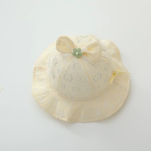 Detail of light yellow baby lace sun hat with floral patterns and pearl bow accent