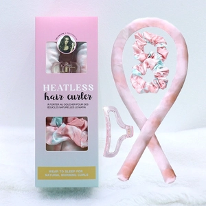 Flat lay of pink tie-dye heatless hair curler set with silk ribbon and hair clips