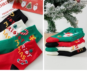 Détail de chaussettes de Noël en coton montrant l'inscription CHRISTMAS et des motifs festifs