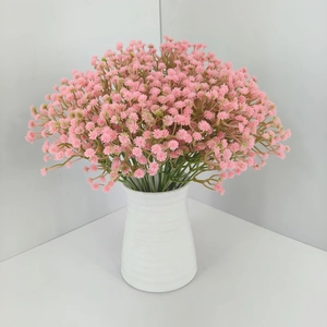 Detailed view of pink artificial gypsophila bouquet in a white textured ceramic vase