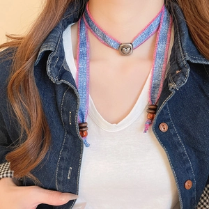 Detailed close-up of blue denim heart choker featuring pink stitching and metal slider
