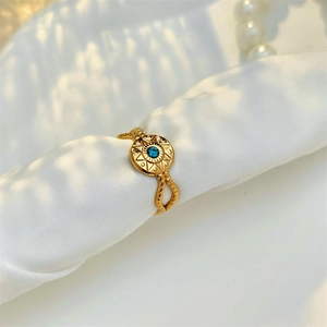 Detailed macro view of vintage gold sunburst ring with blue stone on silk fabric