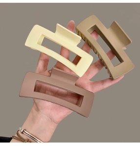 Detailed view of three rectangular matte resin hair claws in beige, tan and dark brown