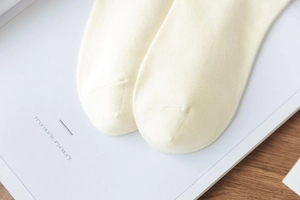 Close-up of seamless toe stitching and knit texture on soft yellow cotton socks