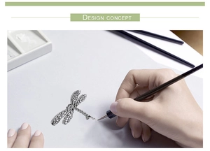 Artistic detail of a dragonfly brooch showing design concept with sketch and diamonds