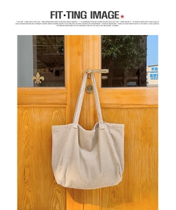 Detail of beige corduroy tote bag showing soft ribbed texture on a wooden door handle