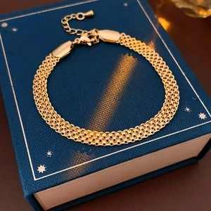 Détail d'un bracelet en maille plaqué or 18 carats sur un écrin bleu nuit étoilé