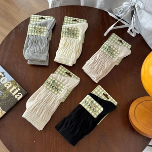 Dettaglio di calze in cotone a coste multicolore con motivi a maglia ed etichette carta