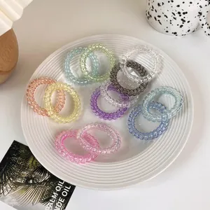 Set of colorful gradient spiral hair ties on a white ceramic tray for summer hairstyles