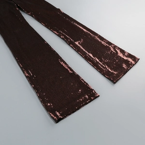 Detailed close-up of shimmering bronze sequins on elegant wide-leg vacation trousers