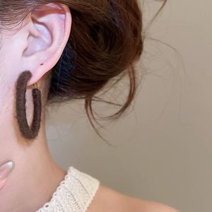 Close-up of brown velvet wrapped hoop earring on model for autumn winter style