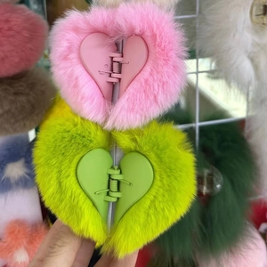 Close-up of heart-shaped faux fur hair claws in pink and neon green for winter styling