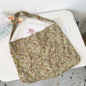 Close-up of a floral canvas tote bag with ginger yellow fabric and small flower patterns