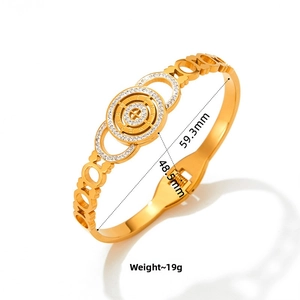 Detailed close-up of gold hollow bangle with Roman numeral disc and paved zircon stones