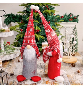 Détail de gnomes de Noël tricotés rouges et gris avec motifs de renne dans la neige