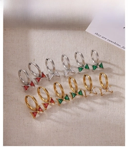 Detail of bow-shaped zircon earrings with colorful gemstones and metallic finishes