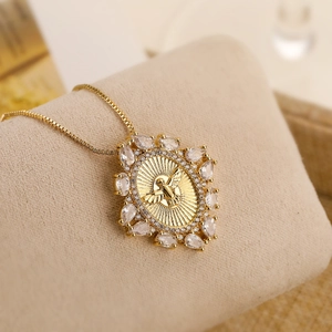 Gold plated bee pendant necklace with marquise zircons on a beige velvet display pad