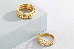 Detail of gold-plated stainless steel crown ring and stackable bands with zircon