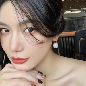 Close-up of a model wearing French vintage round pearl hoop earrings with gold clasp