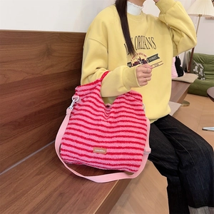 Detail of soft pink and red striped plush crossbody bag with adjustable nylon strap