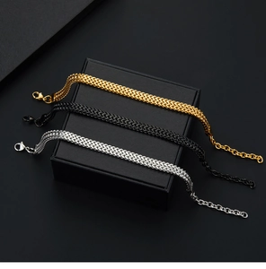 Close-up of triple punk-style stainless steel Cuban chains in gold, black, and silver