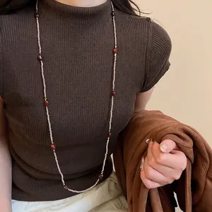 Tiger eye stone beaded necklace layered on model with brown knit sweater