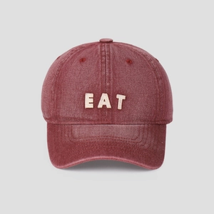 Detail view of burgundy washed denim baseball cap with beige EAT letter embroidery