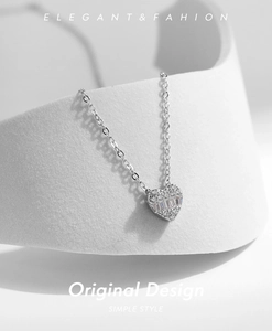 Macro detail of heart pendant with square and round diamonds on 925 silver chain